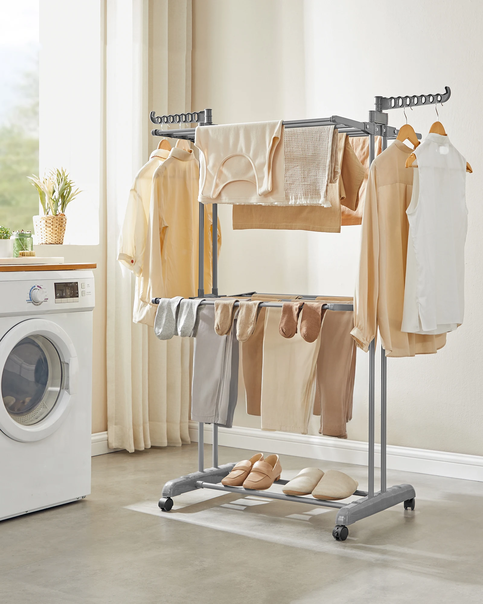 Clothing rack with clothes in a laundry room next to a washing machine.