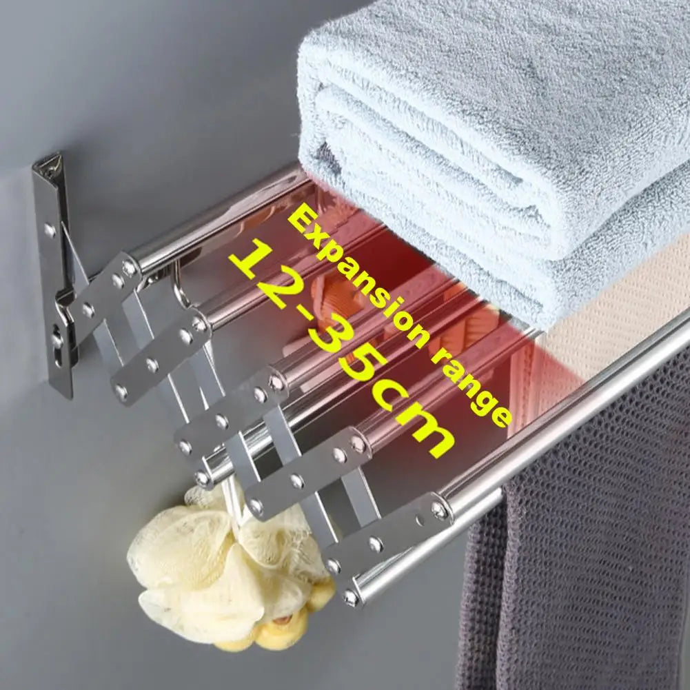 Foldable towel rack with expansion range label on a gray wall with folded towels.