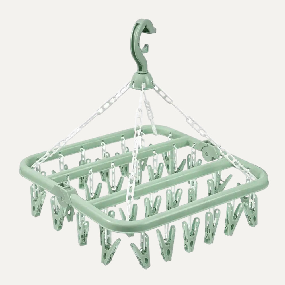 Green clothespin rack with multiple clips on a white background
