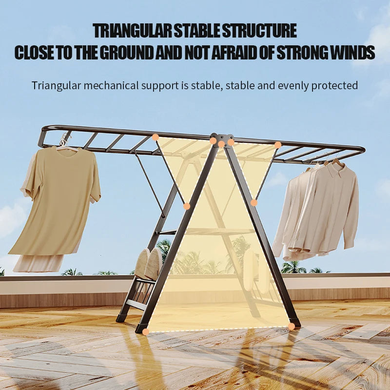 Triangular drying rack with clothes on a wooden floor against a blue sky.