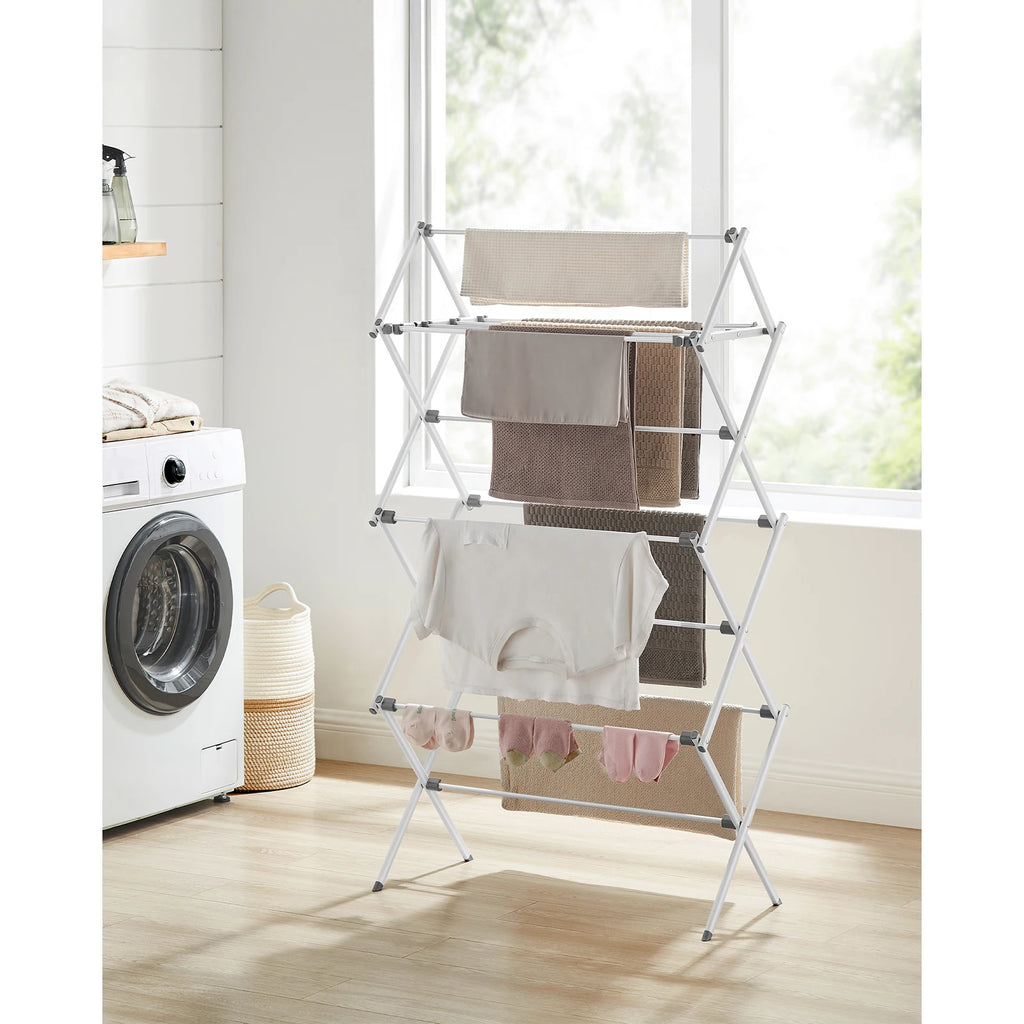 White metal drying rack/airer in a laundry room with a washing machine and basket.