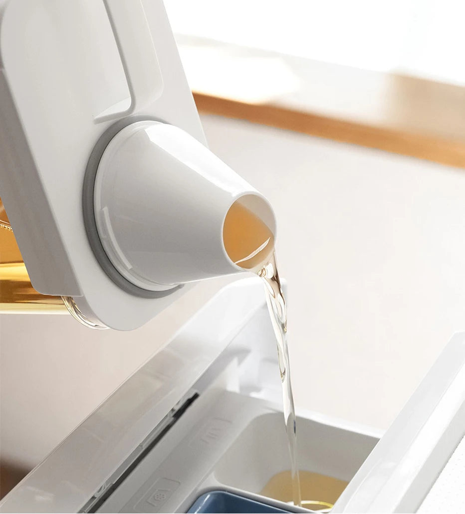 liquid laundry detergent being poured from a Refillable Laundry Detergent Dispenser into a washing machine